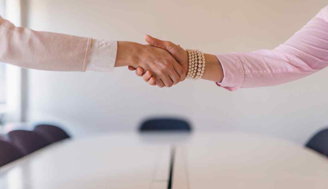 Kaksi henkilöä kättelee.