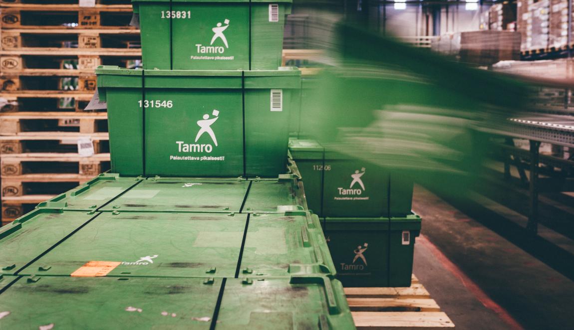 Tamron vihreitä kuljetuslaatikoita pinotaan kuljetuslavalle.