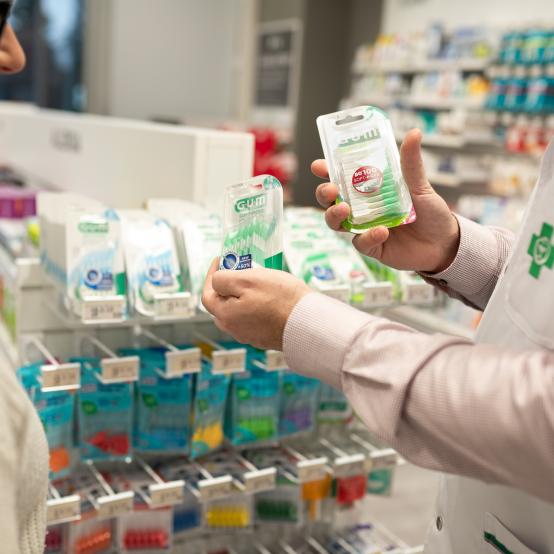 farmaseutti opastaa apteekissa asiakasta suunhoitoon