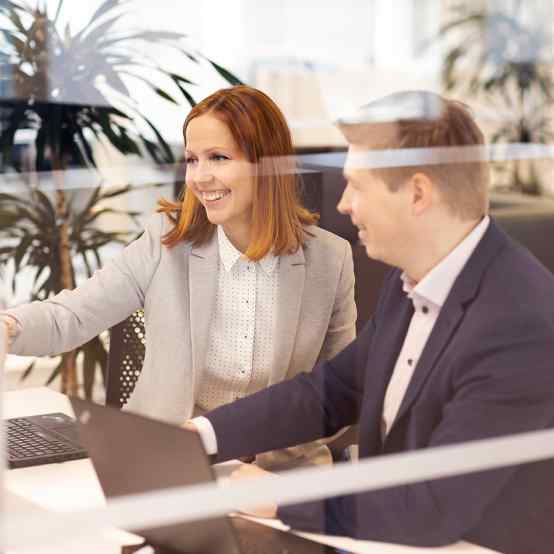 nainen ja mies katsoo näyttöä