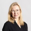 puolilähikuvassa nainen vaaleat hiukset ja silmälasit