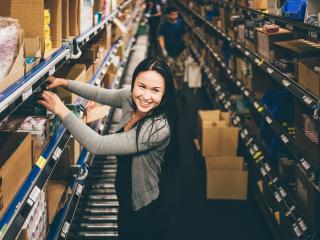 Varastotyöntekijä Tampereen logistiikkakeskuksessa valopaneelikeräilyssä.