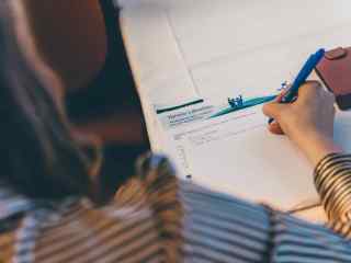 Tamron koulutukseen osallistuva henkilö kirjoittaa muistiinpanoja.