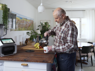 Seniori kotona kahvikuppi kädessä