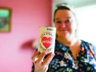 Sydänliiton pääsihteeri Tuija Brax pitelee kädessä tölkkiä, jossa lukee: Auta sydäntä kuntoutumaan.